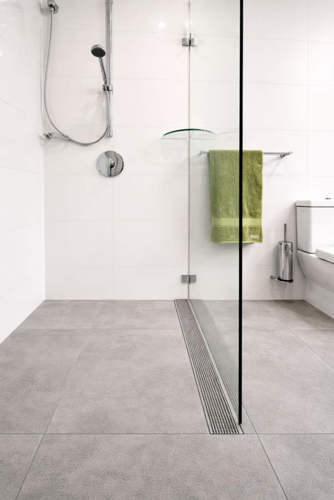 Accessible, step-free livable housing shower with a linear drain