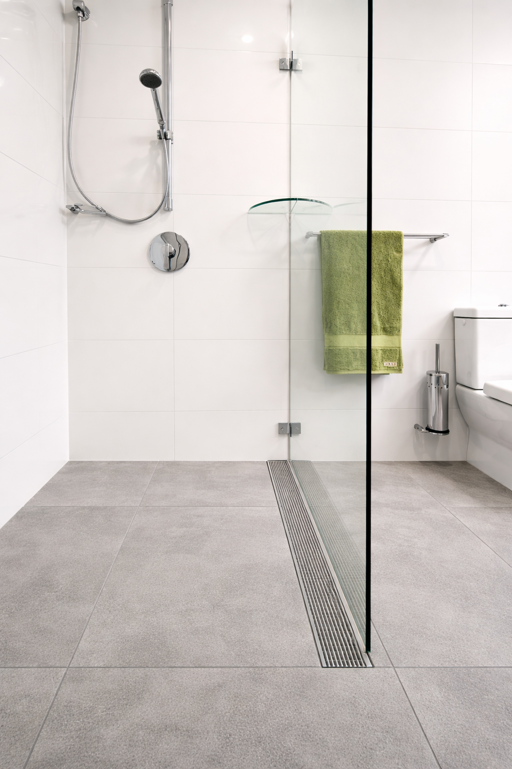 Accessible, step-free livable housing shower with a linear drain