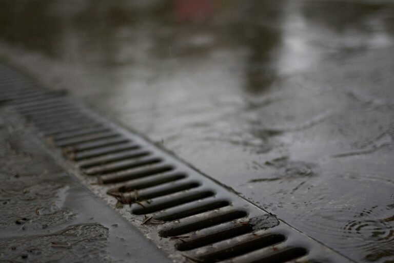 A metal linear drain on a wet concrete surface