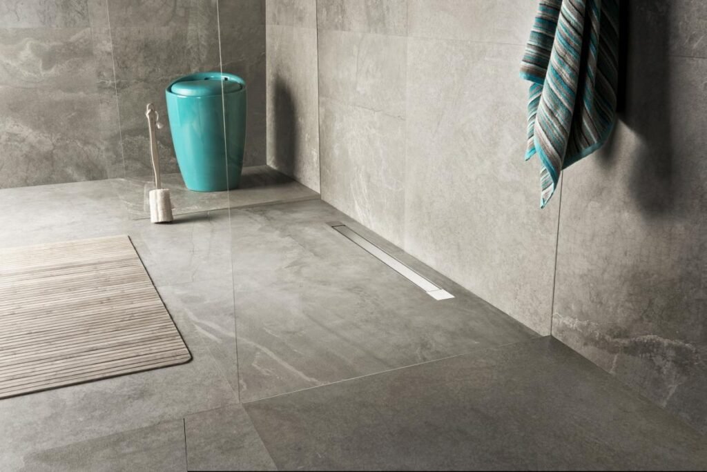 Zero-threshold shower area with a linear drain along the wall